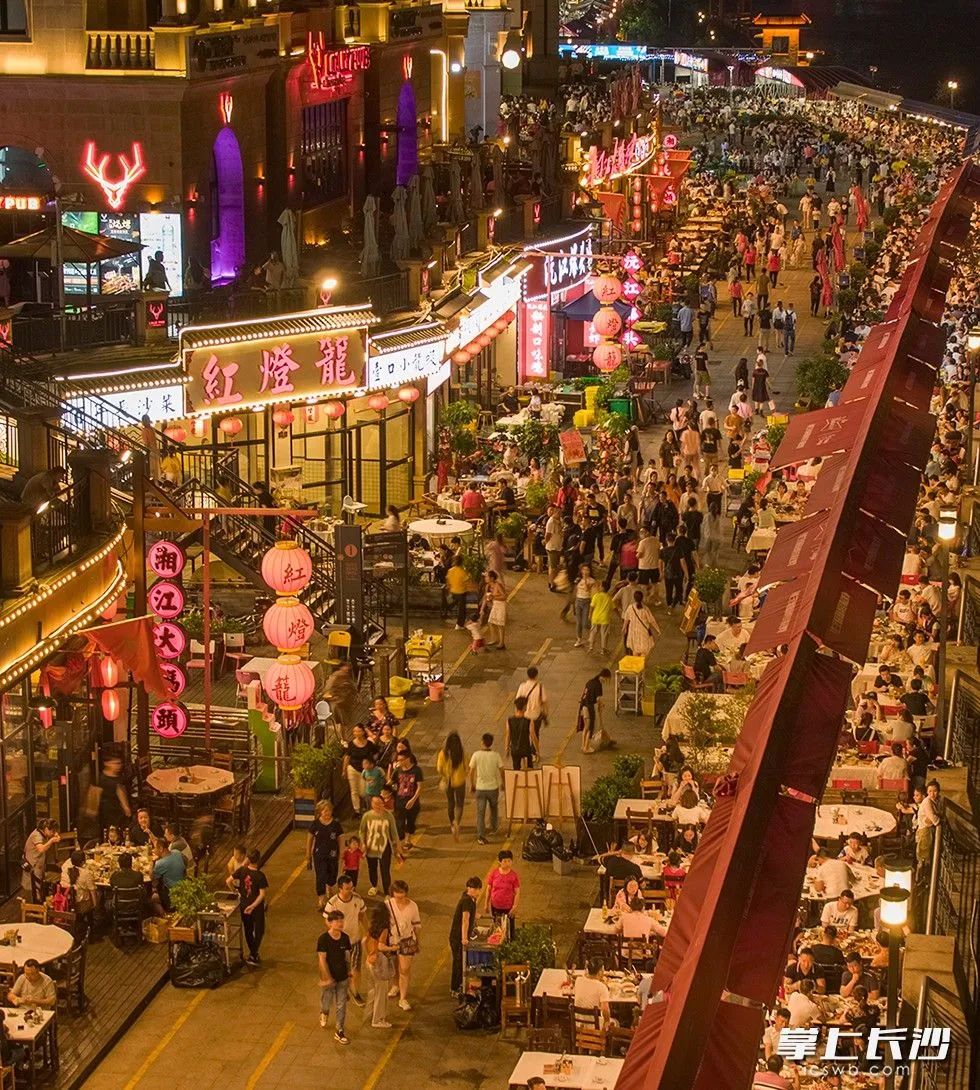 瀟湘北路的漁人碼頭美食街有序擺放的露天餐桌攤擔(dān)前吃夜宵或排隊(duì)的人群與前來(lái)納涼的的路人交織就像置身鬧市街區(qū)